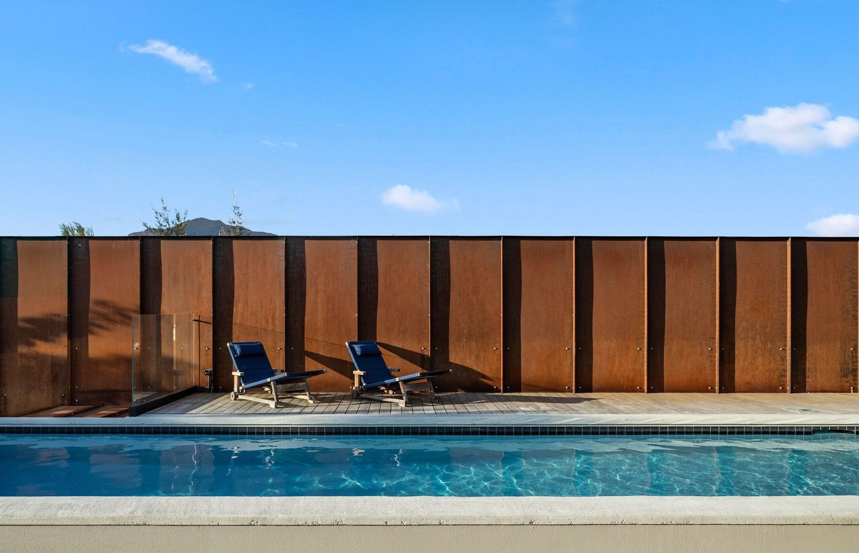 Custom Corten panels have been used to create a fence that not only provides privacy but will also continue to patina over time adding an element of permanency and immutability.