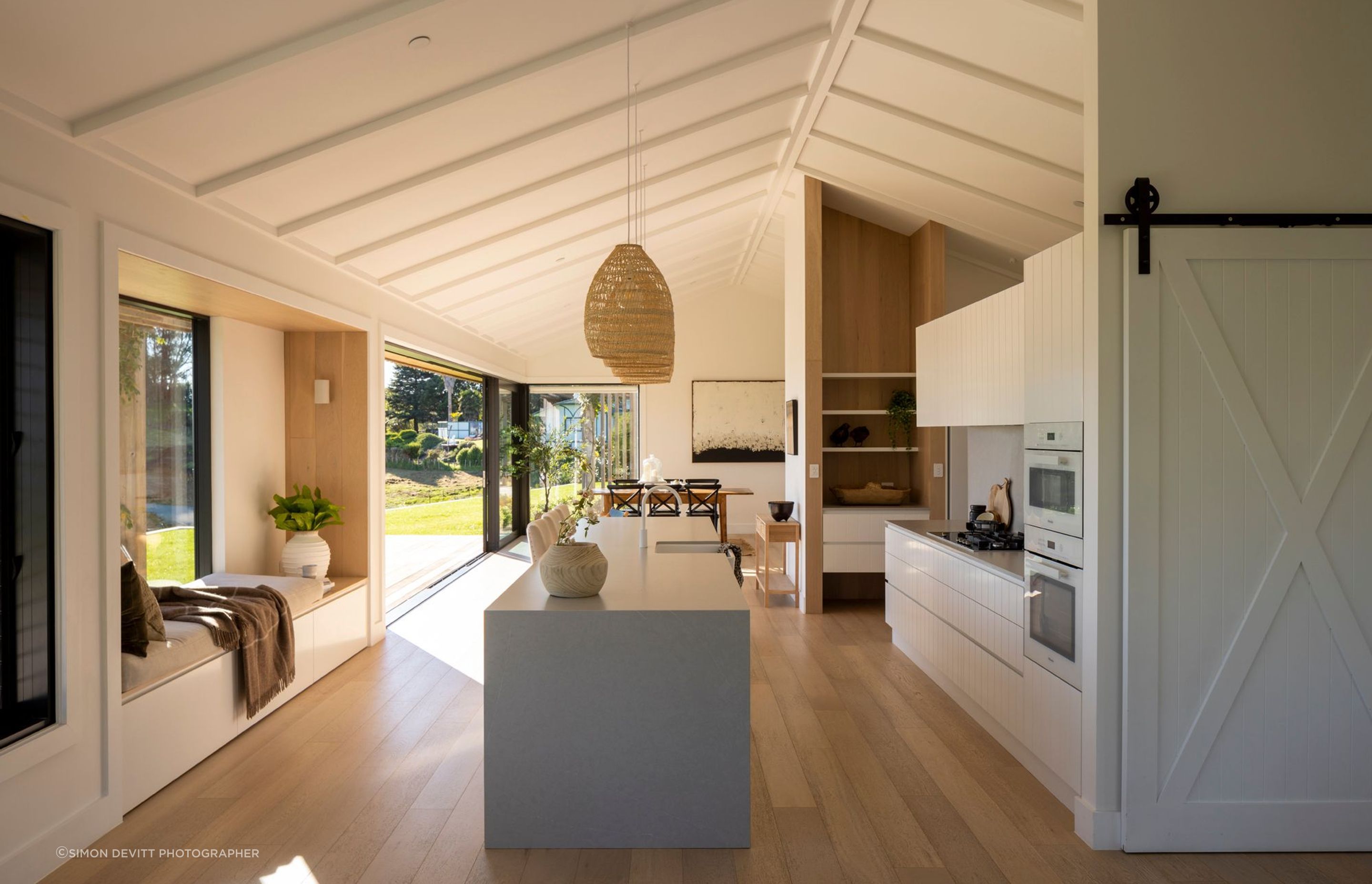 The kitchen/dining space is light and bright, with pale oak floorboards and a kitchen featuring V-groove panelling.