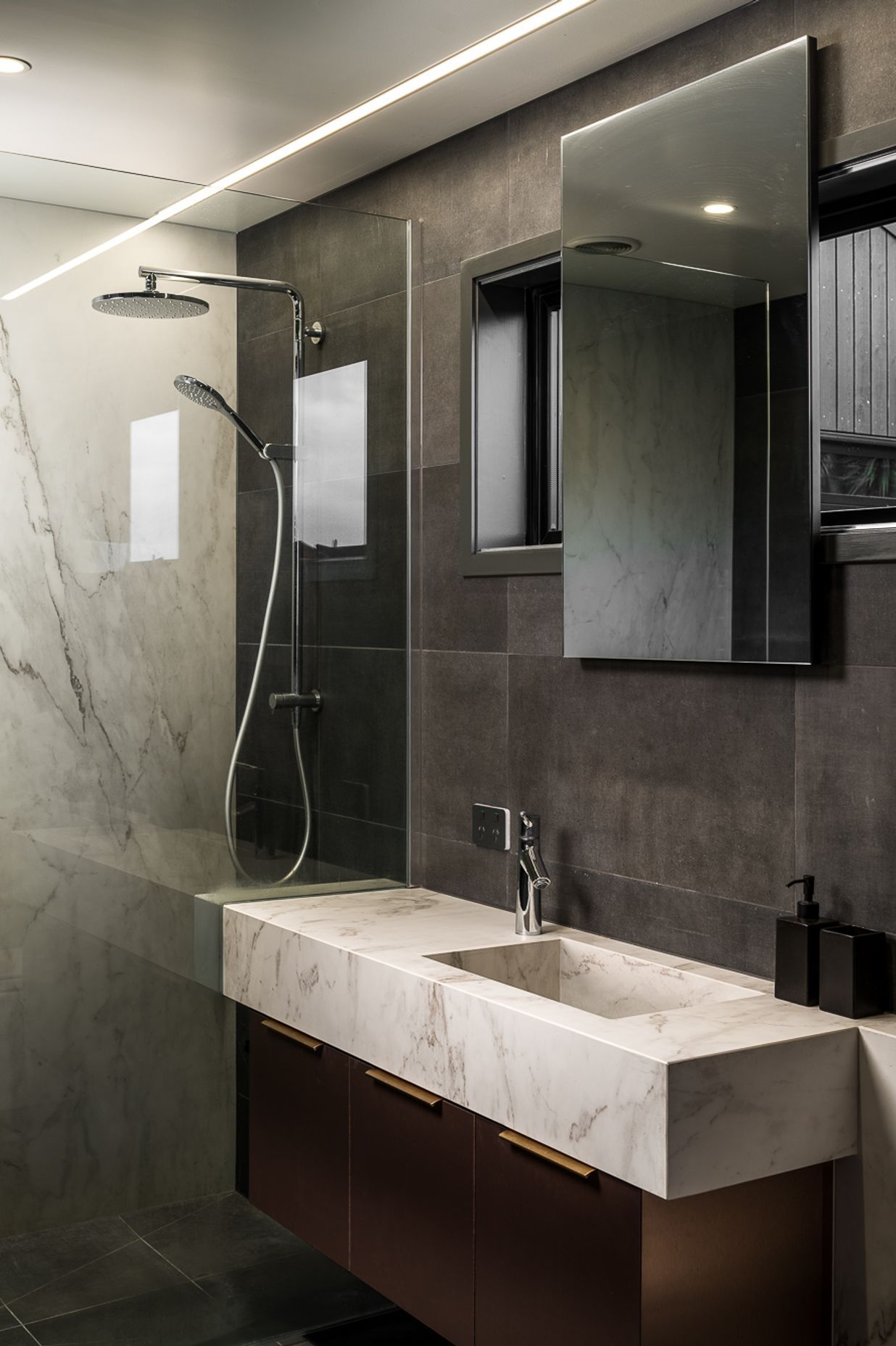 The understated yet richly textural palette continues in the bathroom with its mix of stone and timber.
