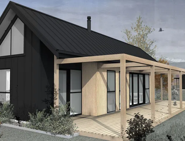 Architectural rendering of a compact contemporary gable-roof house with dark vertical cladding, a black metal roof, expansive black-framed glazing, and a pale timber veranda or deck structure extending along the front. Sparse landscaping surrounds the home, with distant mountains visible in the background.